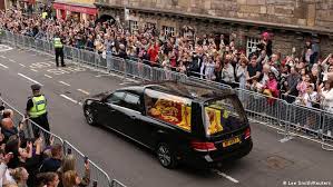 Queens funeral casket arrives Edinburgh, mourners seen line up in street.
